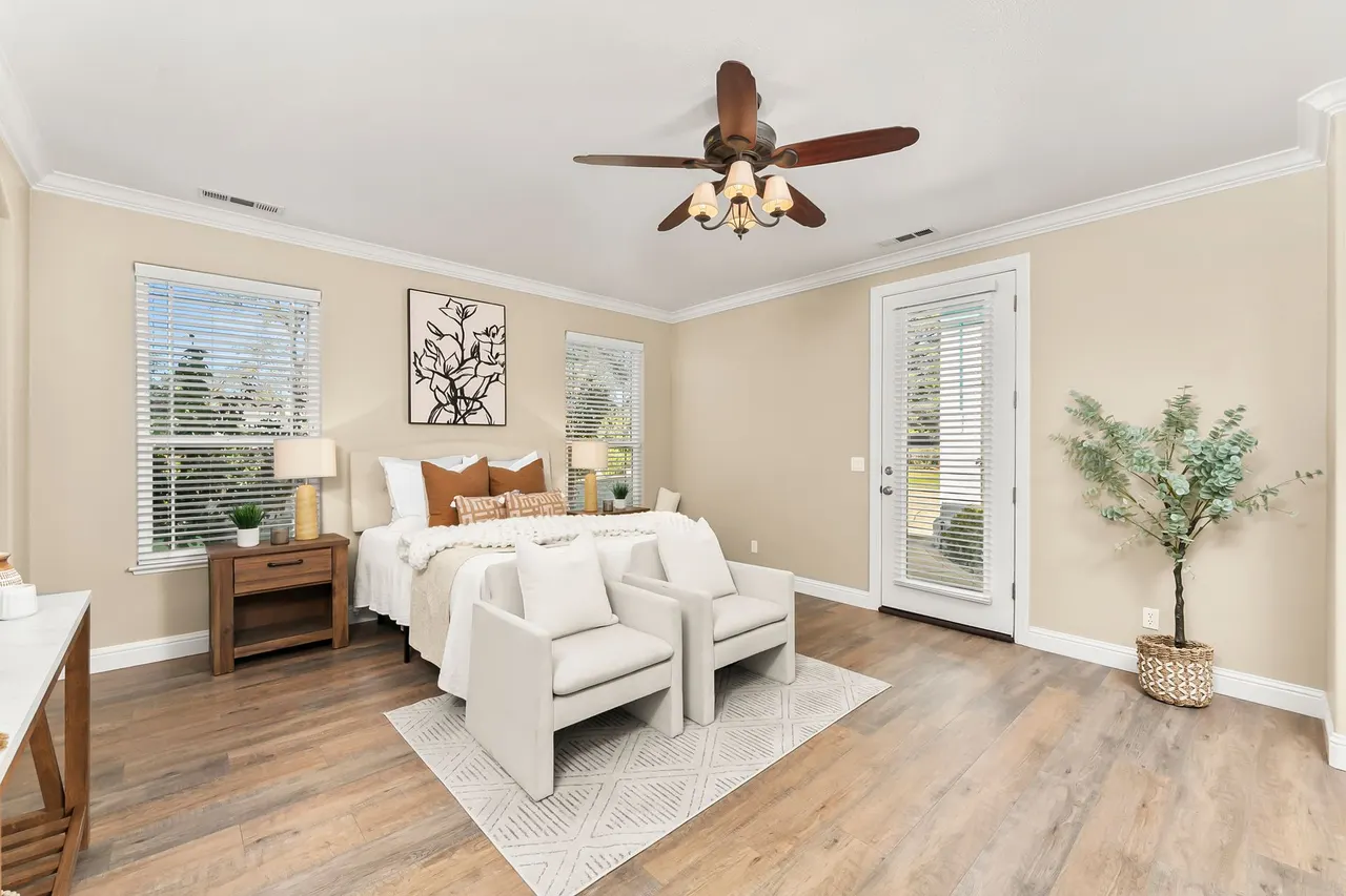 Primary bedroom with ceiling fan and private patio door